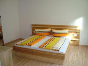 a bedroom with a wooden bed with two pillows at Haus Alexander in Pfunds