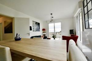 a dining room with a wooden table and chairs at Appartement des Arts in Deauville