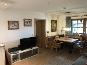 sala de estar con mesa y TV en Ferienwohnung Winklblick, en Reit im Winkl