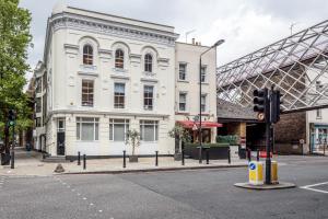 a white building on a city street with a traffic light at The white home near Kensington high st in London