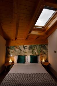 1 dormitorio con 1 cama grande y tragaluz en Apartamentos Turísticos Huerto El Horno en Torremenga