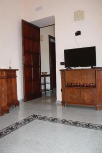 una sala de estar con TV de pantalla plana en una cómoda en Palazzo Giordano Casa Vacanze, en Lauria Inferiore