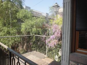 a balcony of a house with trees and flowers at Le jardin des remparts in Colmar