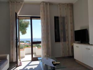 a living room with a tv and a window at SweetHouse Pula in Porto Columbu - Perdʼe Sali