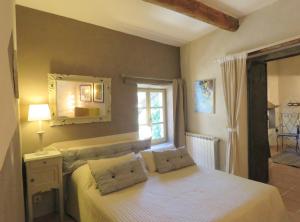 1 dormitorio con cama con espejo y ventana en Les Buis de Lussan en Lussan