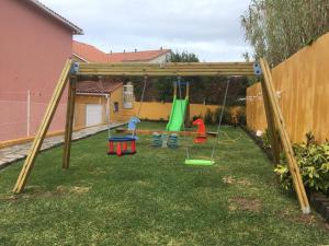 a playground with a swing set in a yard at Apartamentos baltar sanxenxo 1 in Sanxenxo