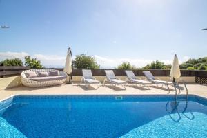 a swimming pool with chaise lounge chairs and a swimming pool at Villa Anna in Tala