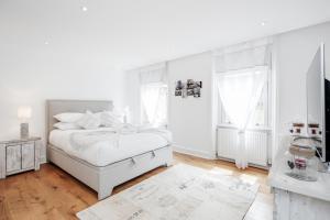 a white bedroom with a bed and a window at The white home near Kensington high st in London