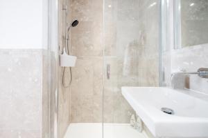 a bathroom with a shower and a sink at The white home near Kensington high st in London +26 photos