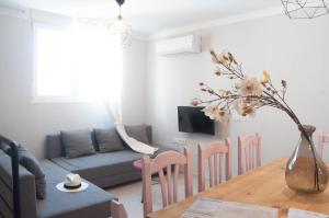 uma sala de estar com uma mesa e um vaso com flores em Apartamentos de la Parte Antigua de Cáceres em Cáceres