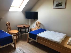 1 dormitorio con 2 camas, mesa y sillas en Prosper Lovasklub Panzió en Piliscsév