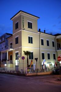 ein großes weißes Gebäude mit einem Zaun davor in der Unterkunft Hotel La Torre in Rimini