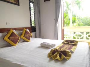 1 cama con 2 toallas y ventana en Village Love Homestay, en Hoi An