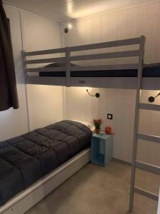 a bedroom with two bunk beds and a table at Camping U Libecciu in Olmeto