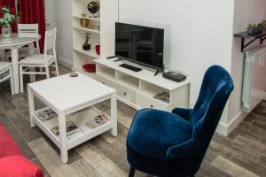 sala de estar con silla azul y TV en El Rincón de Eva en Salamanca