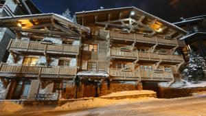 een groot houten huis met balkons in de sneeuw bij Chalet Les Alpes in Val dʼIsère