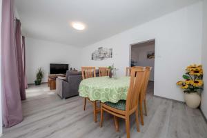 a dining room and living room with a table and chairs at House Stojakovic in Banjol