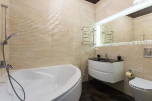 a bathroom with a tub and a toilet and a sink at New luxury Apartment in the Center on Konstitution Square in Kharkiv