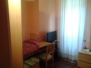 a small room with a desk with a computer and a bed at Hotel Perla in Bologna