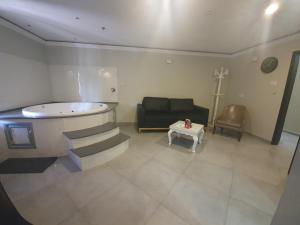 een woonkamer met een bad, een bank en een tafel bij Spat Business Holon in H̱olon