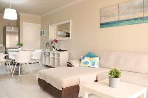 a living room with a couch and a kitchen at CASA JABLILLO in Costa Teguise