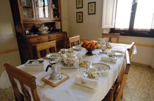 uma mesa de jantar com uma toalha de mesa branca em B&B Cimamori em Poggibonsi