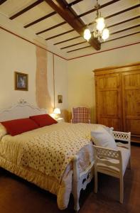 um quarto com uma cama grande e uma cadeira em B&B Cimamori em Poggibonsi