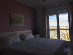une chambre avec un lit et une grande fenêtre dans l'établissement Ryan´s Flat, à Portimão