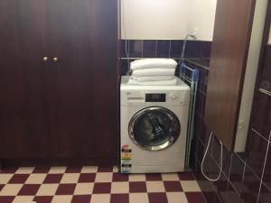 a washing machine in a bathroom with a checkered floor at Gasworks B&B Cottages in Strathalbyn