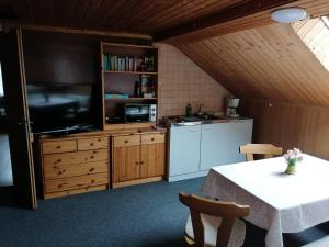 a kitchen with a table and a tv in a room at Ferienwohnung Felsblick in Mittelndorf