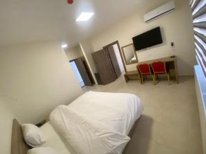 カラクにあるAl-Mujebのベッドルーム1室(ベッド1台、テーブル、椅子付)