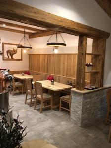 a restaurant with two tables and chairs and wooden walls at Bauernhof Hinterfirst in Söll