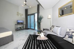 a living room with a couch and a tv at SHH - Furnished Studio in MAG 5, Dubai South Near to Expo 2020 in Dubai