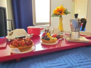 uma mesa vermelha com dois pratos de comida em B&B Cappotto civico 48 em Pompeia