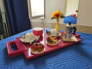 um tabuleiro vermelho com comida numa mesa azul em B&B Cappotto civico 48 em Pompeia