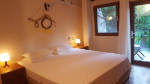 een slaapkamer met een bed met 2 lampen en een raam bij Hotel Villa Monte in Cıralı
