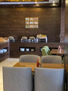 a restaurant with a table and chairs and a counter at ALJAWHARA ALZARQAA FOR SERVISED APARTMENTS Est in Rabigh