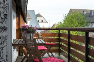 uma varanda com duas cadeiras e uma mesa com flores em Ferienwohnung Stein mit Sauna em Hasselbach