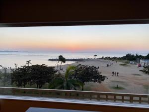 una ventana con vistas a la playa en サンセットビーチホテル, en Chatan