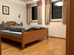 Bett in einem Zimmer mit 2 Fenstern in der Unterkunft Apartment Venediger in Neukirchen am Großvenediger