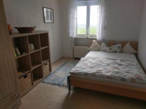 1 dormitorio con cama y estante para libros en Ferienwohnung Wolf en Tittling