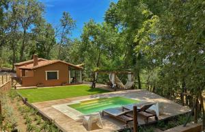 Un patio trasero con piscina y una casa. en El Escondite De Pedro Malillo, en Candeleda 4 fotos más