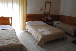 une chambre d'hôtel avec deux lits et un miroir dans l'établissement Pyrassos, à Nea Anchialos