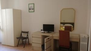Habitación con escritorio, ordenador y espejo. en Hotel Gambara en Milán