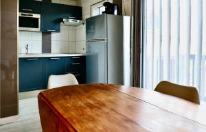 a kitchen with a wooden table and a refrigerator at Le Yearling in Deauville