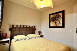 a bedroom with a bed and a picture of a horse at Le Yearling in Deauville