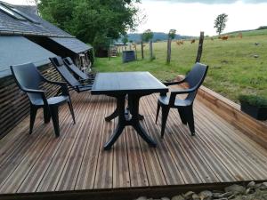 a wooden deck with a table and chairs on it at Le Fournil Gîte Rural in Trois-Ponts