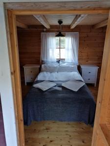a bedroom with a bed in a wooden cabin at Hannuksen Piilopirtti in Tyrnävä