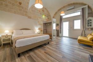a large bedroom with a large bed and a couch at Dimora Cavour in Polignano a Mare