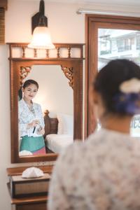 a woman taking a picture of herself in a mirror at Chada Mantra Hotel in Chiang Mai